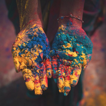 Palms laddened with bright multi-colored powder, possibly depicting the Indian festival of Holi.